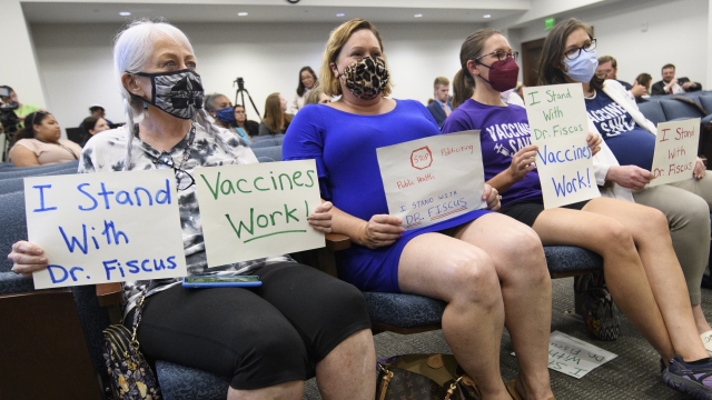 Vaccine advocates wait for the start of a state legislative committee meeting