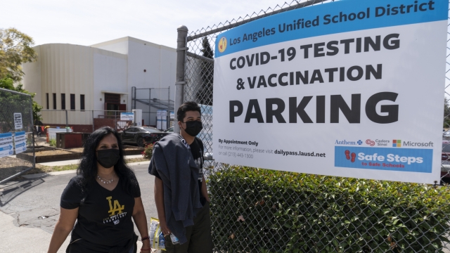 Californians leaving a COVID-19 testing and vaccination site in Los Angeles.