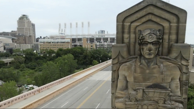 Statue stands in front of a stadium.