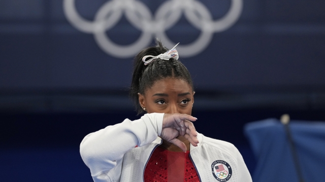 Simone Biles, of the United States, watches gymnasts perform at the 2020 Summer Olympics