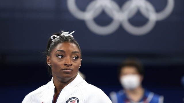 Simone Biles, of the United States, watches gymnasts perform at the Olympics.