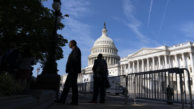 The U.S. Capitol is seen as people are walking on the sidewalk.