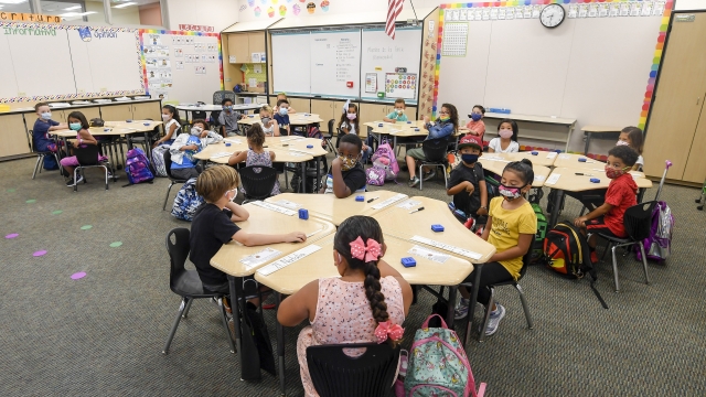 Masked students sit in their classroom on the first day of school