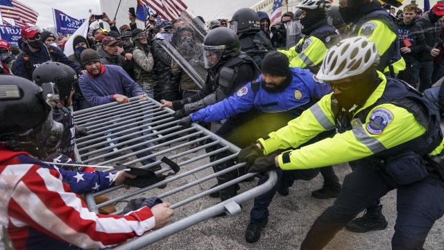 Violent insurrectionists loyal to President Donald Trump hold on to a police barrier at the Capitol in Washington on Jan. 6.