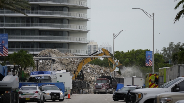 An excavator removes the rubble of the demolished section of the Champlain Towers South building.