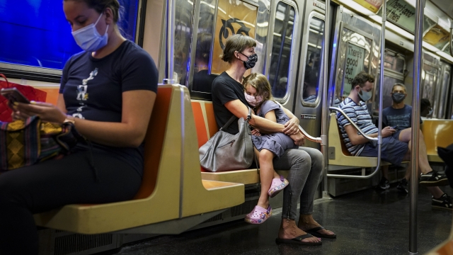 Parent and child wear masks on subway