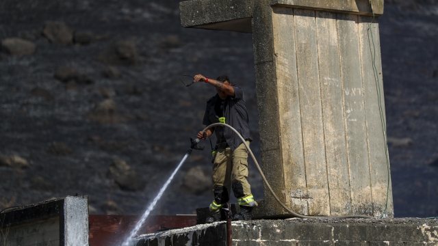 An Israeli firefighter works to extinguish a fire caused by rocket fired from Lebanon into Israeli territory