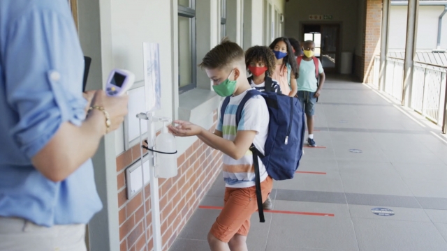 Kids sanitize before entering a classroom
