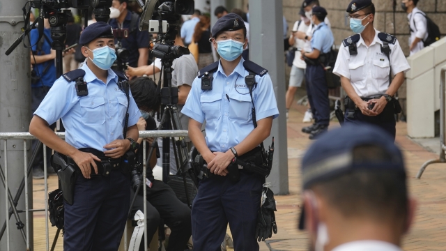 Police officers stand guard outside a court Friday, July 30, 2021, in Hong Kong