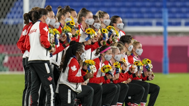 The Canadian women's national soccer team poses with their Olympic gold medals.