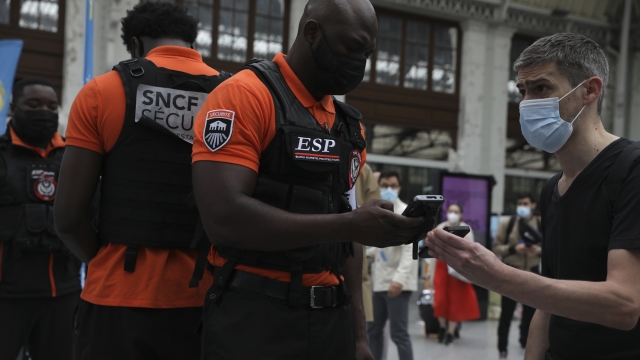 Security officers check passengers' health passes at the Gare de Lyon train station in Paris Monday Aug.9, 2021