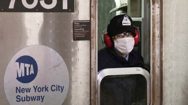 A subway conductor wears a face mask as the train is in a station, in the Bronx borough of New York.