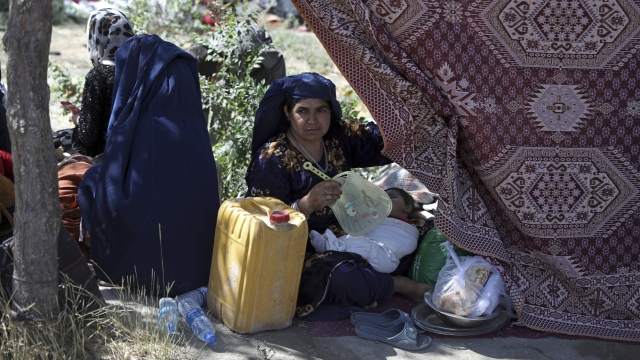 An internally displaced Afghan woman from a northern province sits with her child in camp in Kabul.