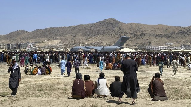 Hundreds of people gather near a U.S. Air Force C-17 transport plane at a perimeter at the international airport in Kabul