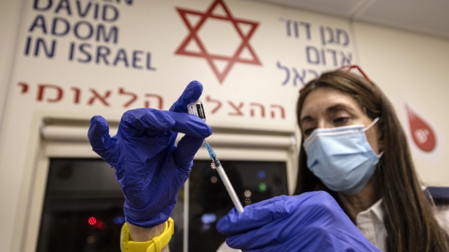 A medic from Israel's Magen David Adom emergency service prepares a booster shot of the coronavirus vaccine