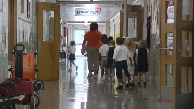 Kids walk down a hallway.