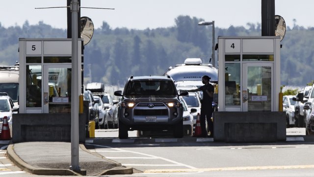 A Canada Border Services Agency officer hands documents back to a motorist entering Canada at the Douglas-Peace Arch border