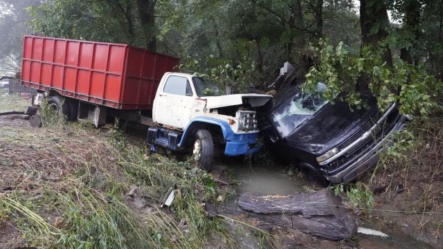 A truck and a car sit in a creek after they were washed away the day before in McEwen, Tenn.