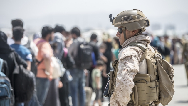 A marine provides assistance during an evacuation at Hamid Karzai International Airport in Kabul, Afghanistan.