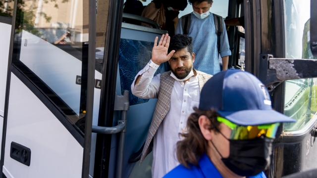 A man waves as he and other Afghanistan refugees arrive at a processing center in Chantilly, Va., Monday, Aug. 23, 2021.