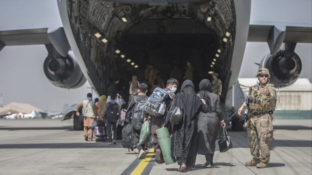 Families begin to board a U.S. plane during an evacuation at Hamid Karzai International Airport.