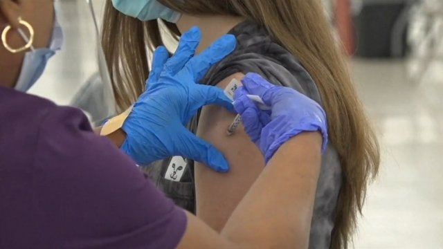 Nurse injects shot into woman's arm.