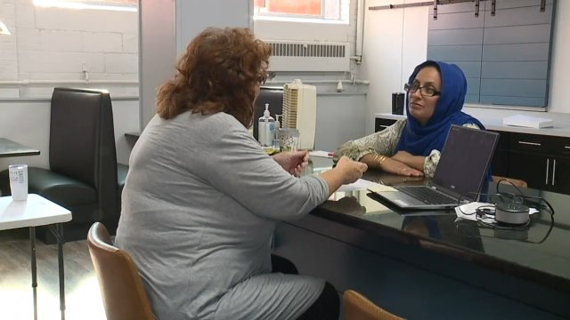 Two women sit at a desk.