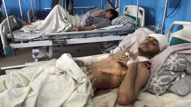 Afghans lie on beds at a hospital after they were wounded in the deadly attacks outside the airport in Kabul, Afghanistan.