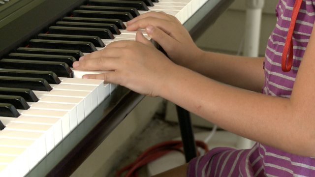 Girl plays the piano.