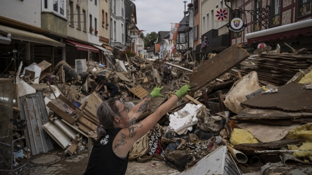 A woman throws away rubbish in the center of Bad Neuenahr-Ahrweiler, Germany, after heavy rainfall in 2019.