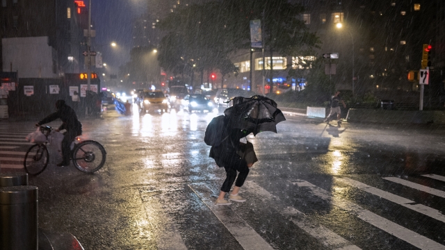 Pedestrians take cover from the rain near Columbus Circle in New York.