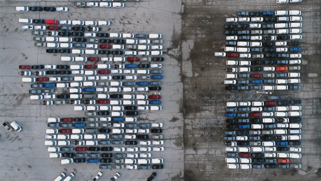 Pickup trucks and vans are seen in a parking lot outside a General Motors assembly plant