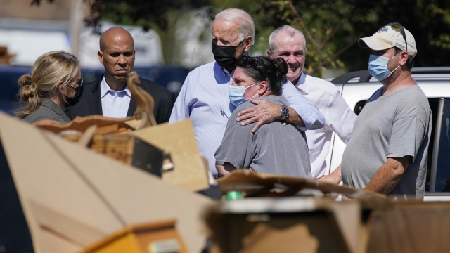 President Joe Biden hugs a person as he tours a neighborhood impacted by Hurricane Ida