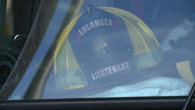 Firefighter helmet sits in window.