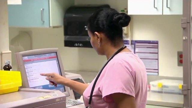 Nurse touches a screen.