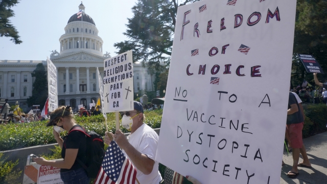 Protesters opposing vaccine mandates march past the Capitol in Sacramento, California.