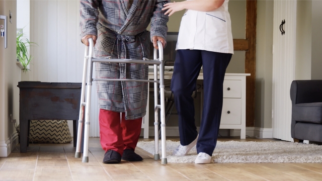 Nursing home staff member helps elderly patient
