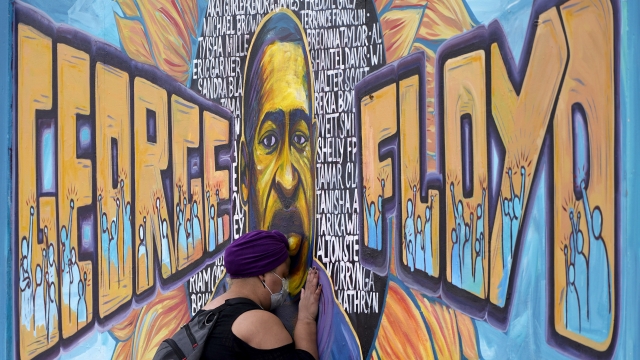 Damarra Atkins pays her respects to George Floyd at a mural at George Floyd Square.