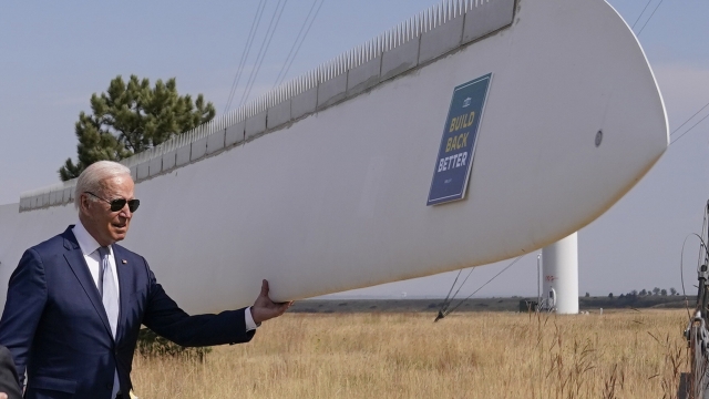 Pres. Biden holds onto a wind turbine blade during a tour at the Flatirons campus of the National Renewable Energy Laboratory