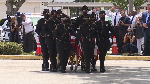 Officers carry a casket.