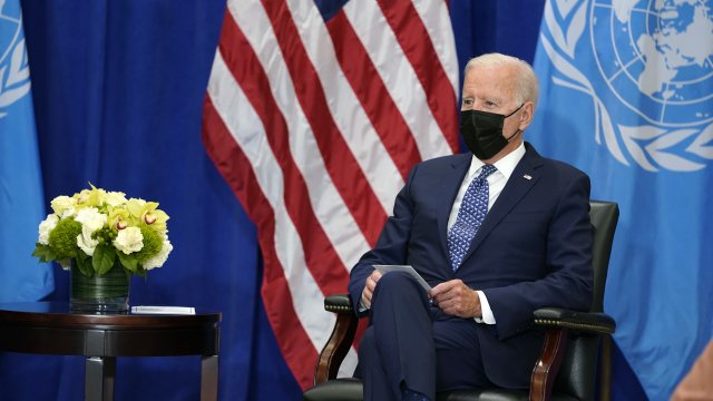President Joe Biden sits before U.N. flag