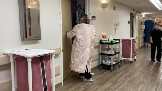 Woman walks into a hospital room.
