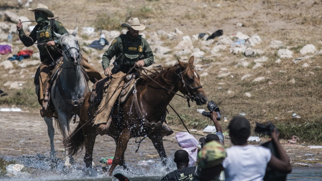 U.S. Border Patrol agents attempt to contain migrants as they cross the Rio Grande from Mexico into Texas.
