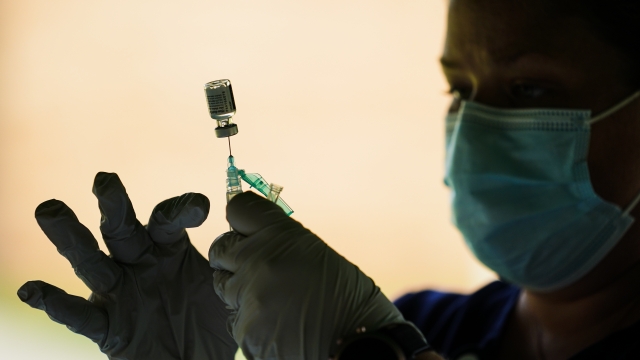 A syringe is prepared with the Pfizer COVID-19 vaccine at a clinic