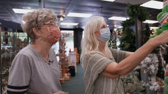 Two women look at a holiday store display.