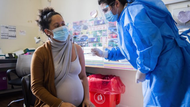 A nurse gives a shot of the Pfizer vaccine for COVID-19 to a pregnant woman