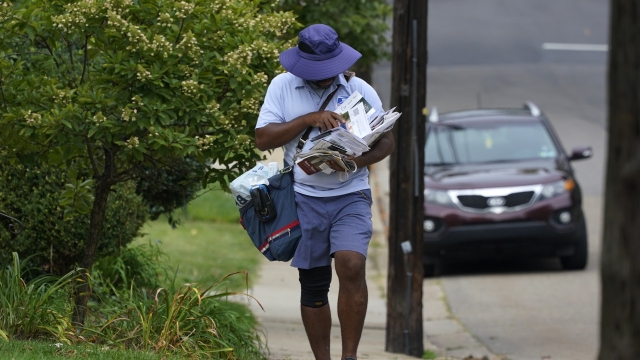 A U.S. Postal Service carrier walks his route to deliver the mail