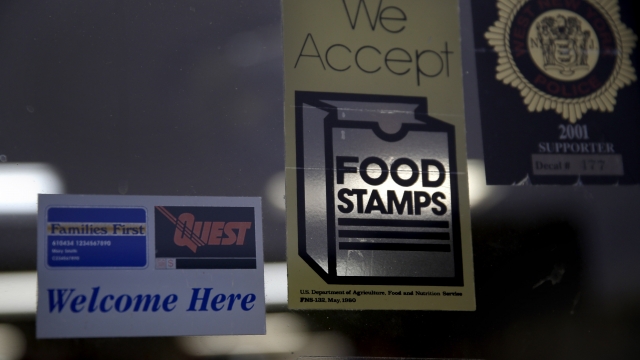Stickers in a supermarket window indicating the store accepts food stamps