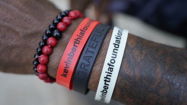 A man wears bracelets with the name of his mental health foundation on them