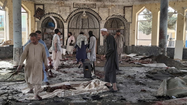 People view the damage inside of a mosque following a bombing in Kunduz province in northern Afghanistan.